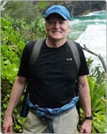 Jerry Rau outdoors in a cap with a backpack