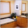 The same master bathroom after, with a granite tub deck