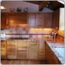 The same kitchen after, with new wood cabinets and stone counters